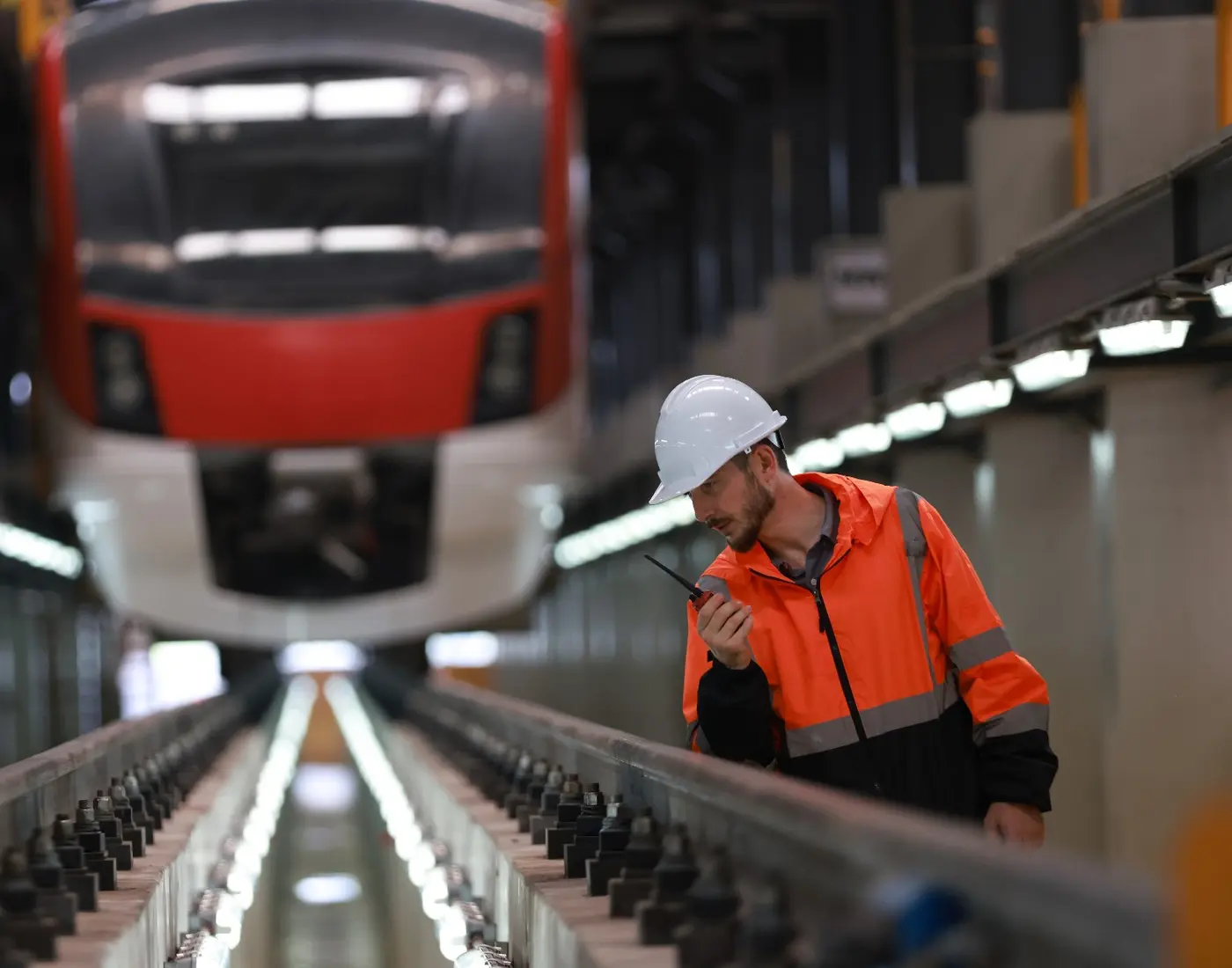 Railway engineer working alongside a train in a maintenance depot